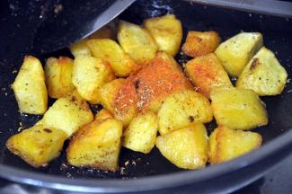 土豆煎好后，倒出多余的油，倒入辣椒粉、花椒粉。