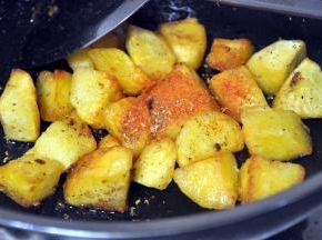 土豆煎好后，倒出多余的油，倒入辣椒粉、花椒粉。