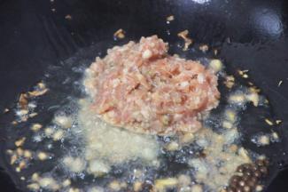 紧接着倒入肉末。