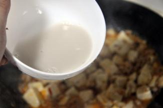 待汤汁慢慢收干，豆腐吸收了肉的香味，倒入生粉水勾芡。