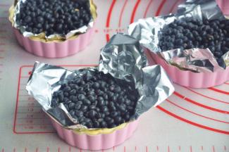 在派皮上放锡纸，压上石子或者豆子。