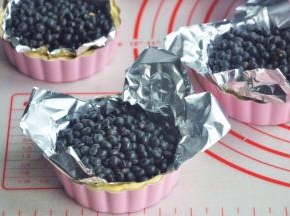 在派皮上放锡纸，压上石子或者豆子。