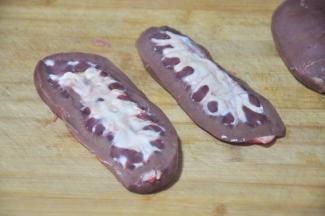 猪腰横切两半后去掉中间白色部分和内部比较红的一层，清洗干净，这一步非常重要，不然会有异味。