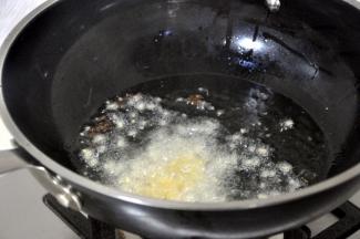 接着放入蒜和姜末，快速炒出香味。