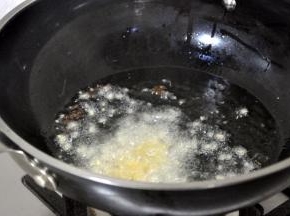 接着放入蒜和姜末，快速炒出香味。