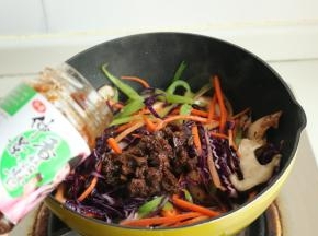 放入2大勺香菇酱，继续炒匀。