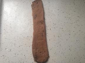 取一个面团擀成椭圆形，拍调多余气泡