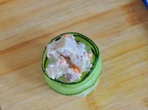 再在上半部分，用一片黄瓜片卷起，要比米饭高一些，填入之前拌好的金枪鱼肠。