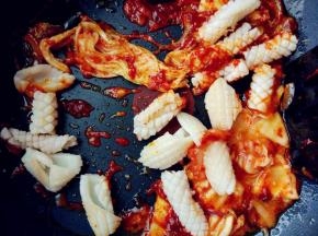 下辣白菜、鱿鱼和盐，翻炒几下，出锅前洒少许鸡粉提味