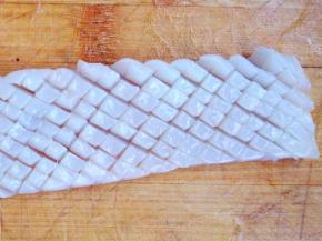 在腹部内侧那一面，先“左上右下”的方向切均匀的条，底部切透不切断