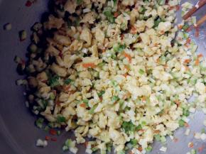 将西葫芦丁、胡萝卜丁、青椒丁和鸡蛋碎倒在一起，加植物油、盐和生抽拌匀