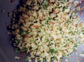 将西葫芦丁、胡萝卜丁、青椒丁和鸡蛋碎倒在一起，加植物油、盐和生抽拌匀