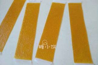 将果丹皮从垫子上撕下来，放在油纸上，然后裁成条状