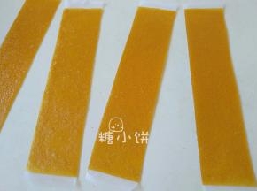 将果丹皮从垫子上撕下来，放在油纸上，然后裁成条状
