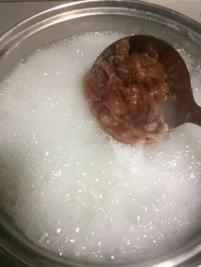 把米煮开花后开大火加入瘦肉滚一分钟