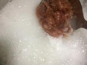 把米煮开花后开大火加入瘦肉滚一分钟