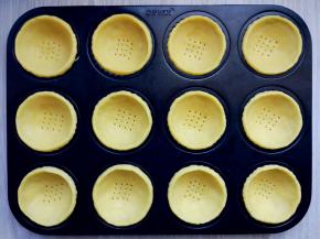 将挞皮揪小块，在手心压成薄饼后，放入模具中，用手指沿四周压紧，边缘捏一圈稍高的沿