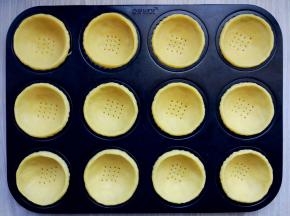 将挞皮揪小块，在手心压成薄饼后，放入模具中，用手指沿四周压紧，边缘捏一圈稍高的沿