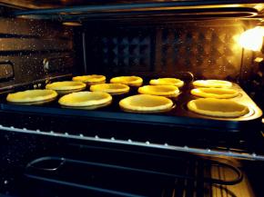 入预热好的烤箱，上火190度，下火170度，烤10分钟左右。具体时间和温度要根据不同烤箱实际炉温酌情增减，原配方是上/下火分别为205/180，烤18-20分钟，但是由于我压的挞皮稍薄，如果用这个温度和时间无疑是要烤糊的。