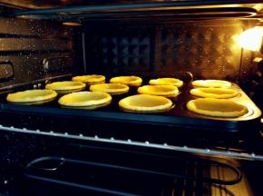 入预热好的烤箱，上火190度，下火170度，烤10分钟左右。具体时间和温度要根据不同烤箱实际炉温酌情增减，原配方是上/下火分别为205/180，烤18-20分钟，但是由于我压的挞皮稍薄，如果用这个温度和时间无疑是要烤糊的。