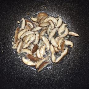 锅中倒入油，大火烧热，下入蒜末和香菇煸出香味。