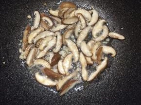 锅中倒入油，大火烧热，下入蒜末和香菇煸出香味。