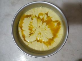 将芒果泥倒在慕斯糊上，不用特意倒得很均匀，用牙签随意拉花。放入冰箱冷藏过夜。