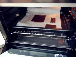 将可可面团在两张油纸间擀成均匀的厚片，另切几个稍粗的细条做钢琴支架，放入ACA烤箱中层，上下火155度烤10分钟左右