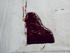 另外用微波炉融化少许黑巧克力，装入剪口裱花袋，在油纸上画出钢琴盖的形状，入冰箱冷藏至凝固。同样用白巧克力涂成长条薄片，冷藏至凝固