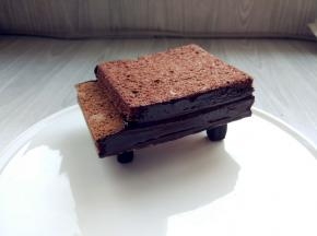 将钢琴支架顶部粘少许黑巧克力，放在盘中合适位置，将钢琴主体放在上面，侧面涂少许巧克力（或甘纳许）