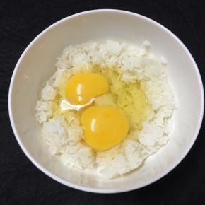 米饭倒入较大的碗里，打入鸡蛋。
