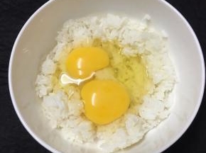 米饭倒入较大的碗里，打入鸡蛋。