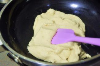 将绿豆泥倒入锅中，小火炒至完全吸收黄油，水分略干的状态，过程中要不断的翻炒。