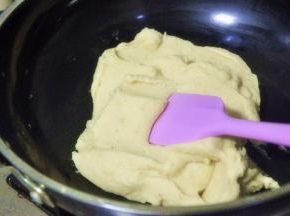 将绿豆泥倒入锅中，小火炒至完全吸收黄油，水分略干的状态，过程中要不断的翻炒。