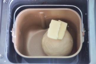 揉至面筋扩展，表面光滑，加入软化的黄油。