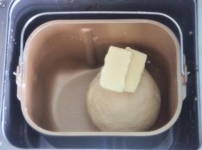 揉至面筋扩展，表面光滑，加入软化的黄油。