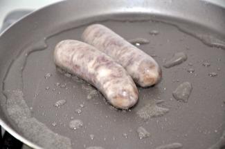 现在来准备披萨馅料，平底锅中倒入少量油，小火煎香肠，我用的珍妮珍馐的秘制原味纯肉香肠，不含淀粉，小朋友很喜欢。