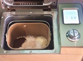 把液体材料放入面包桶中，面粉铺在上面，对角分别上放上盐、糖、可可粉，在面粉中间挖一个小坑，放上酵母，启动面包机揉面程序10分钟。