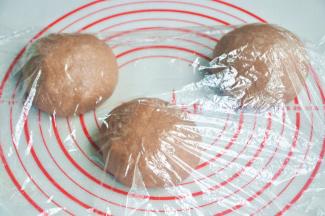 将面团取出，按揉排气后面团均分成三团，盖上保鲜膜松弛15分钟。