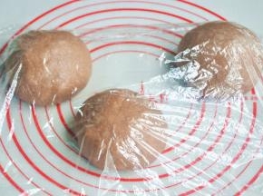 将面团取出，按揉排气后面团均分成三团，盖上保鲜膜松弛15分钟。