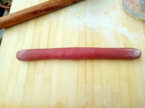 案板上撒上适量干粉，把面团搓成长棍状