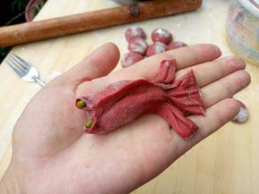 用刀把尾巴划开，整理一下鱼尾，然后放上两颗绿豆在眼眶部位，作为眼睛