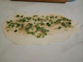 取其中一个小面团擀成长圆形面饼。把油酥平铺在面饼上，下面的边可以擀薄一点，为了最后好粘合，