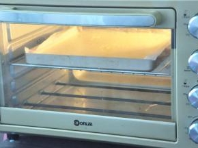 将蛋糕糊倒入垫好油纸的烤盘中，轻轻震出大气泡，放入提前预热好的烤箱，145度28分钟。