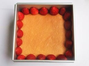 草莓去蒂切半，将草莓剖面紧贴模具壁摆好。