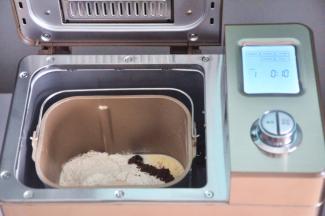 把液体材料放入面包桶中，面粉铺在上面，对角分别上放上盐、糖、奶粉，在面粉中间挖一个小坑，放上酵母，启动面包机揉面程序10分钟。