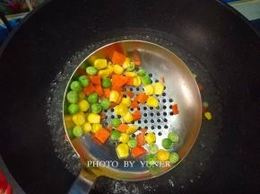 把焯过的什锦蔬菜捞出，控干水份，放入金枪鱼的碗中；