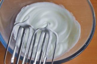 在蛋清中分三次加入糖粉，低速打发，直至蛋白越来越细腻，提起一个小弯勾。