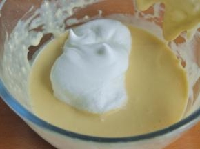 将少量蛋白霜加入到蛋黄糊中，切拌均匀。