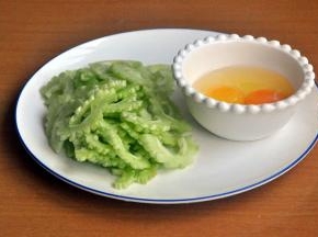 准备材料，苦瓜切成2半，将中间的瓤去掉，然后将苦瓜内层的白色膜刮除干净，减少苦瓜的苦涩感，斜切薄片。